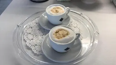 two cups of coffee sitting on a glass plate at Cima Bianca in San Vito lo Capo