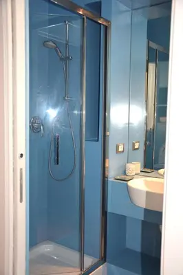 a blue bathroom with a shower and a sink at Luci della città Palazzo San Matteo in Palermo