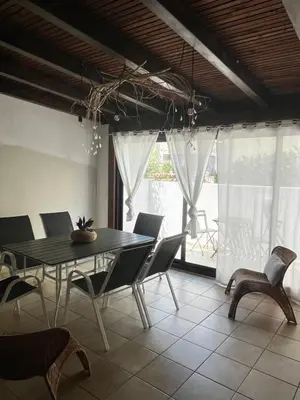 a dining room with a black table and chairs at Sicilia Vacation in San Vito lo Capo