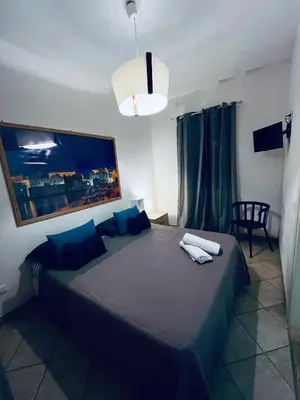 a bedroom with a large bed with blue pillows at Sicilia Vacation in San Vito lo Capo