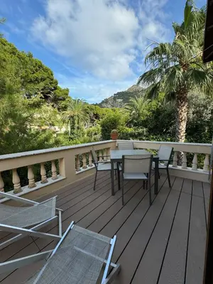 a wooden deck with a table and chairs on it at A un passo dal mare in Lido di Mondello