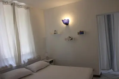 a bedroom with a bed with a purple lamp on the wall at A un passo dal mare in Lido di Mondello