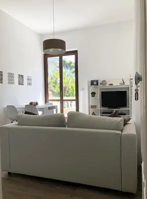 a living room with a couch and a tv at A un passo dal mare in Lido di Mondello