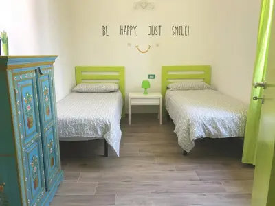 a room with two beds and a dresser in it at A un passo dal mare in Lido di Mondello