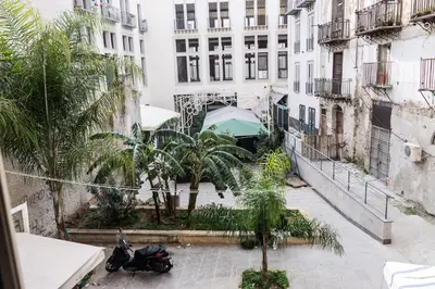 a large building with palm trees in front of it at B&B Into Palermo Rooms vicino al teatro Massimo in Palermo