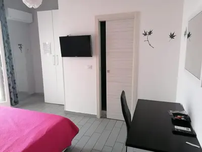 a bedroom with a bed and a table and a tv at Casa Normanna in Monreale