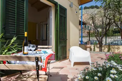 a patio with a table and a bottle of wine at Nonna Anna Rooms in Palermo
