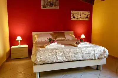 a bedroom with a bed with red walls and two lamps at Al Duomo in Partinico