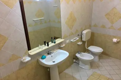 a bathroom with a sink and a toilet and a mirror at Al Duomo in Partinico