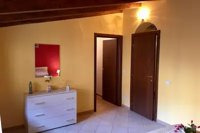 a bedroom with a white dresser and a door at Al Duomo in Partinico