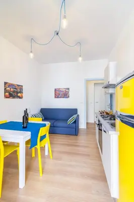 a kitchen and living room with yellow and white appliances at Casa Turano in Castellammare del Golfo