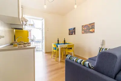 a living room with a blue couch and a table at Casa Turano in Castellammare del Golfo