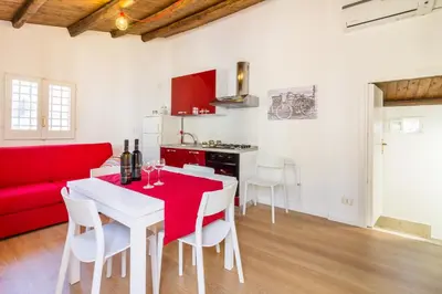 a living room with a table and a red couch at Casa Turano in Castellammare del Golfo