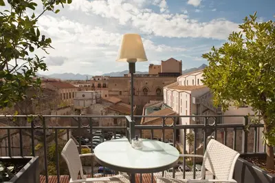 a table and chairs on a balcony with a view of a city at Hotel Porta Felice & Spa in Palermo