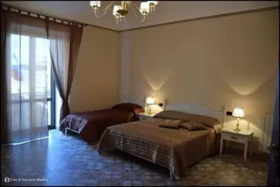 a bedroom with two beds and a chandelier at b&b Caravella in Mezzojuso