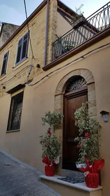 a building with two plants in front of a door at b&b Caravella in Mezzojuso