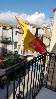 a flag hanging on a balcony of a building at b&b Caravella in Mezzojuso