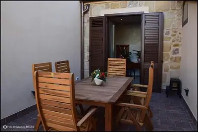 a wooden table and chairs on a patio at b&b Caravella in Mezzojuso