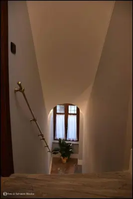 a room with a staircase with a window and a plant at b&b Caravella in Mezzojuso
