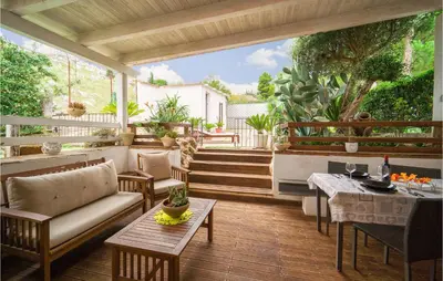 a patio with a couch and tables on a deck at Palermo Per Due in Torretta