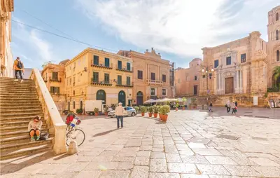 a group of people walking down a street with buildings at Palermo Per Due in Torretta