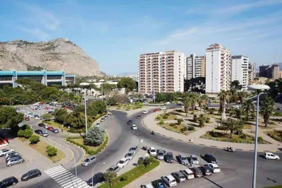 a parking lot with cars in a city with buildings at Favorita suites in Palermo
