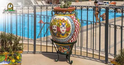 a large colorful vase sitting next to a pool at Agriturismo le Campanelle - Sicilia - Cefalù in Lascari
