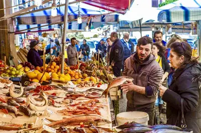 a man and woman standing at a market with seafood at Capo House in Palermo