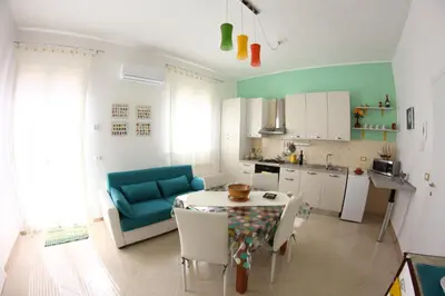 a kitchen with a table and a blue couch at Casa Vacanze Aurora in Balestrate