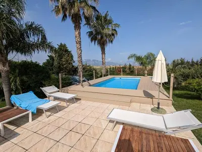 a swimming pool with a bench and an umbrella at Isola del sole, Appartamenti con piscina in Balestrate
