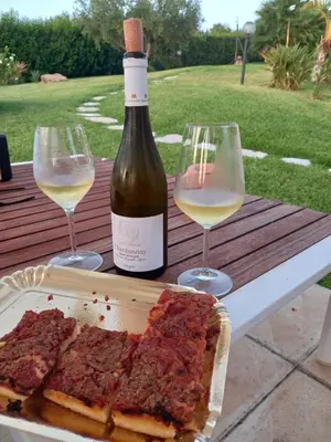 a table with two wine glasses and a bottle of wine at Isola del sole, Appartamenti con piscina in Balestrate