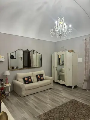 a living room with a couch and a chandelier at Le Alcove in Cinisi