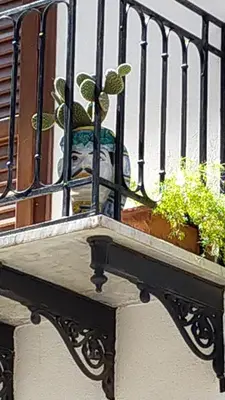 a balcony with potted plants on a building at Le Alcove in Cinisi