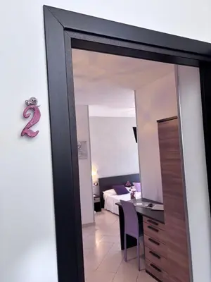 a mirror in a room with a table and a bed at B&B La Chiocciola in Castelluzzo