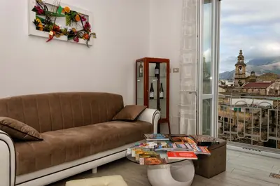 a living room with a couch and a large window at Le Cupole Decò in Palermo