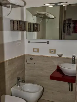 a bathroom with a toilet and a sink and a mirror at Le Cupole Decò in Palermo
