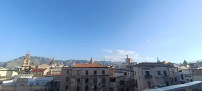 a city with buildings and mountains in the background at Le Cupole Decò in Palermo