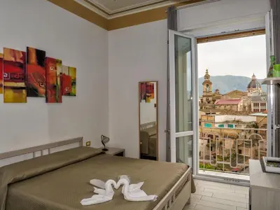 a bedroom with a bed and a large window at Le Cupole Decò in Palermo