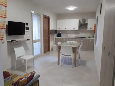 a kitchen and dining room with a table and chairs at Casa Vacanza Demi in Alcamo Marina