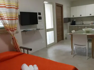 a living room with a kitchen and a dining room table at Casa Vacanza Demi in Alcamo Marina