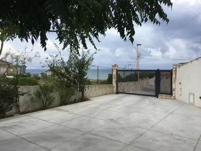 a driveway with a black gate and a view of the ocean at Casa Vacanza Demi in Alcamo Marina