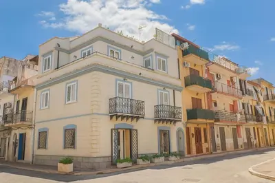 a large white building with balconies on a street at Matilde Boutique Hotel by AR Group Hotels in Isola delle Femmine