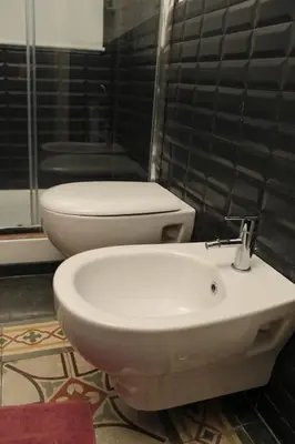a bathroom with a toilet and a sink at 3Sisters Apartments in Palermo