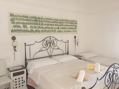 a bedroom with two beds and a picture on the wall at Ballarò Holiday in Palermo