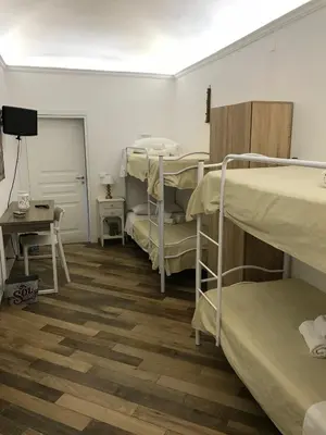 a room with three bunk beds and a table at Ballarò Holiday in Palermo