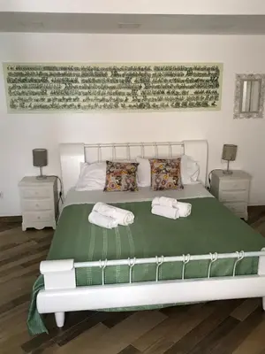 a bedroom with a white bed with two towels on it at Ballarò Holiday in Palermo