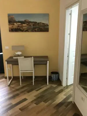 a desk in a room with a chair and a painting at Ballarò Holiday in Palermo