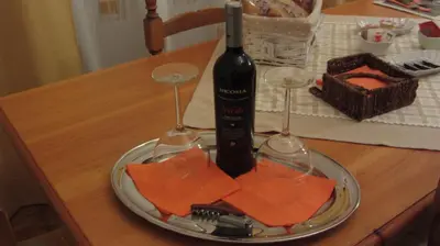 a plate with a bottle of wine and two wine glasses at Villa Margherita in Terrasini