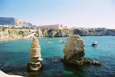 two stacks of rocks in the water with boats at Villa Margherita in Terrasini