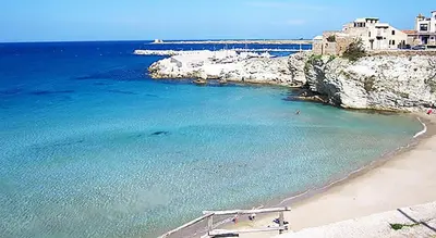 a beach with a group of people in the water at Villa Margherita in Terrasini